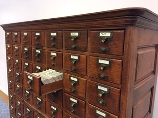 Antique card catalog with open drawer
