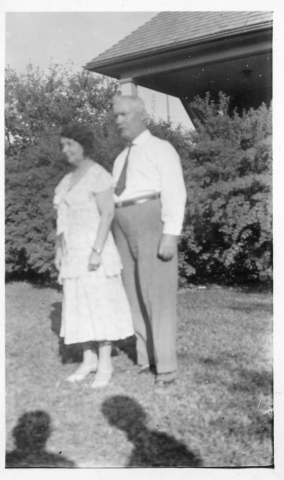 Nester and Covey family - man and wife standing in front of their home