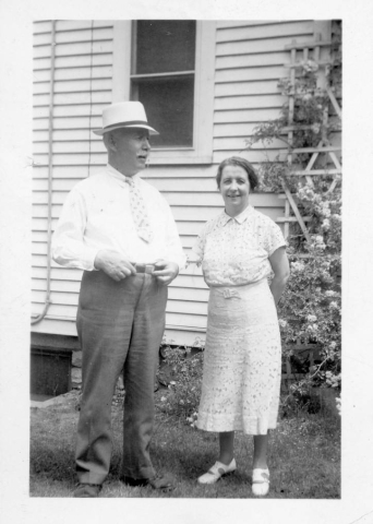 Nester and Covey family - man and wife standing outside of their home