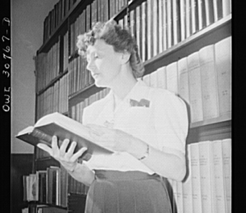 historical image of a librarian holding a book, in front of a book shelf