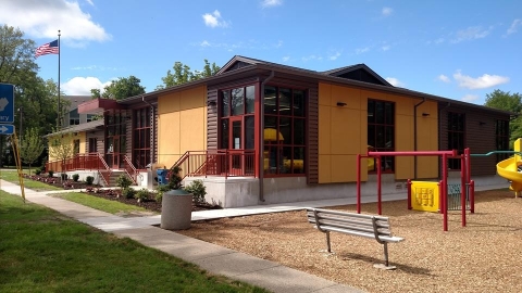 Exterior of library tan and brown library building with playground